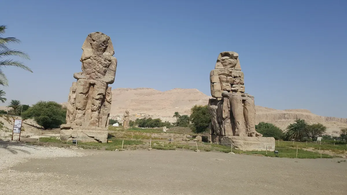 The two Colossi of Memnon standing on the Theban plain with the West Bank hills behind, seen on a Valley of the Kings tour