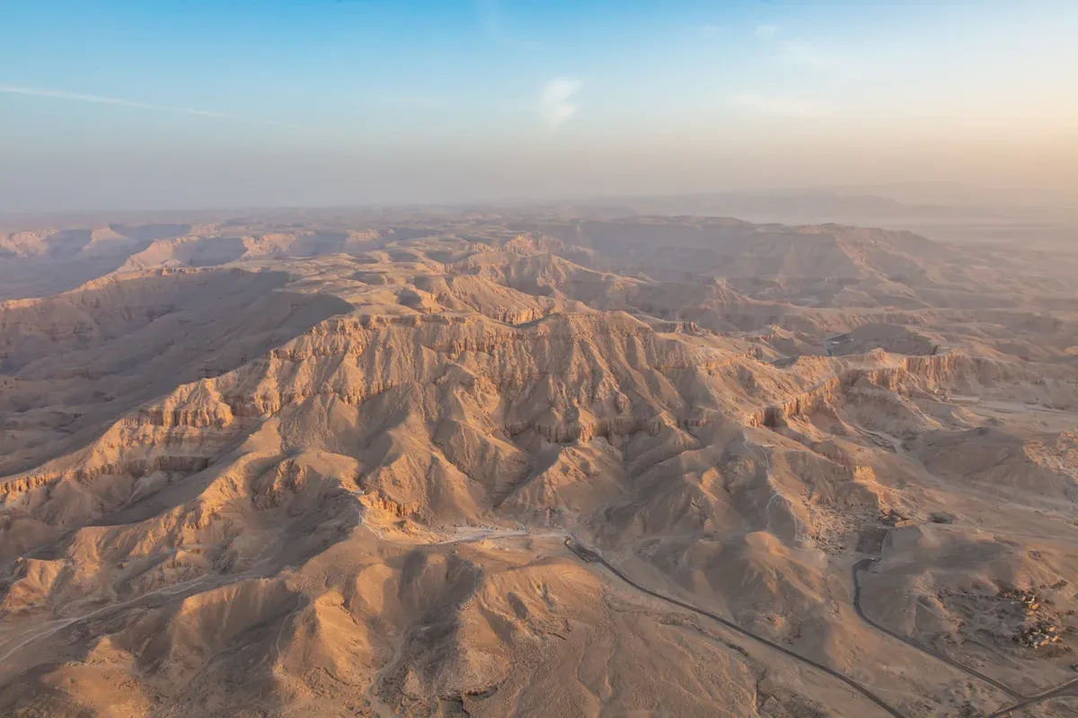 An aerial view of the desert hills and access road of the Valley of the Kings, seen on a Valley of the Kings tour