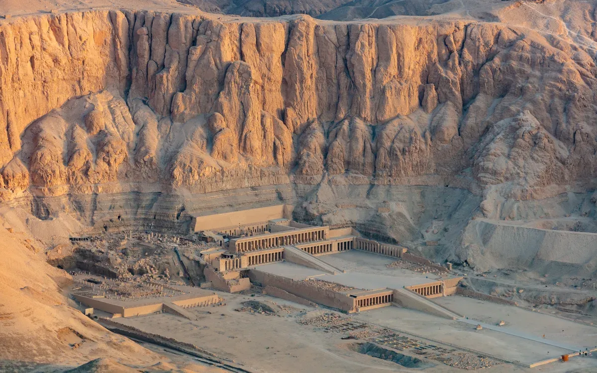 An aerial view of Hatshepsut's terraced temple below the Deir el-Bahari cliffs, seen on a Valley of the Kings tour